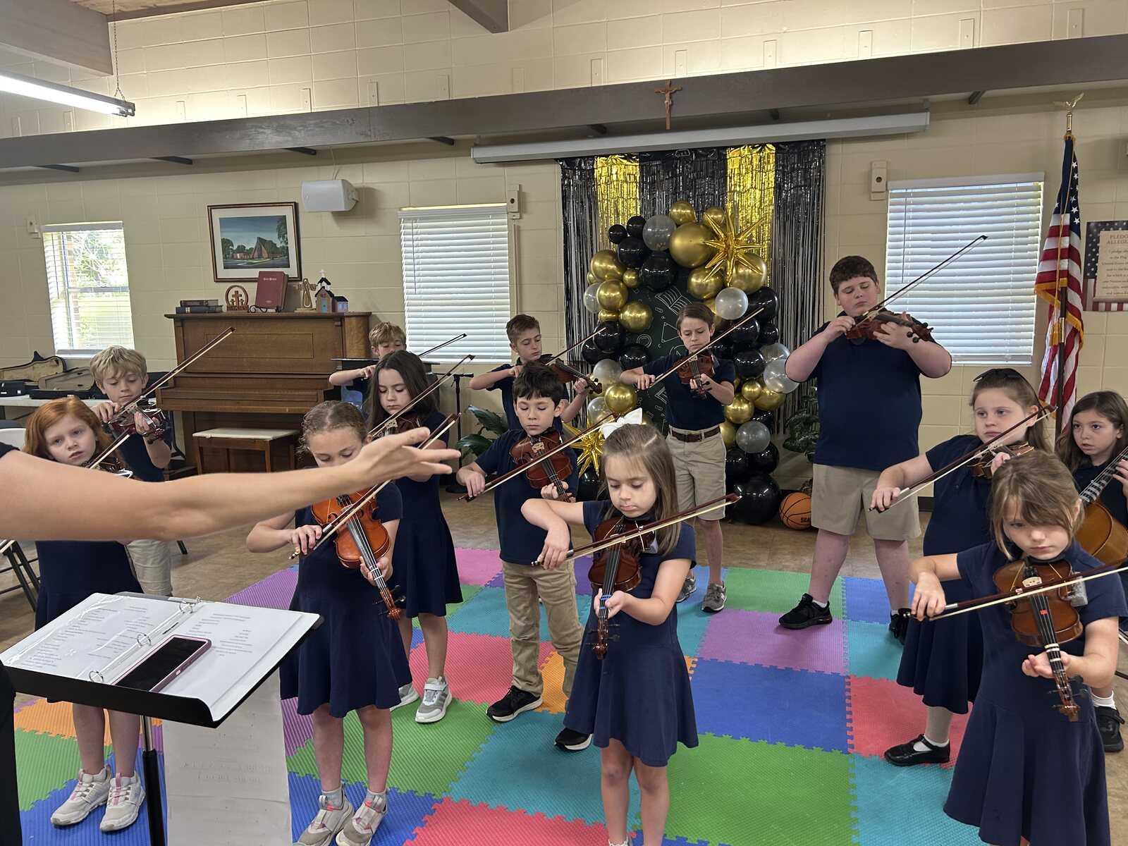 Veritas students learning violin together with their teacher